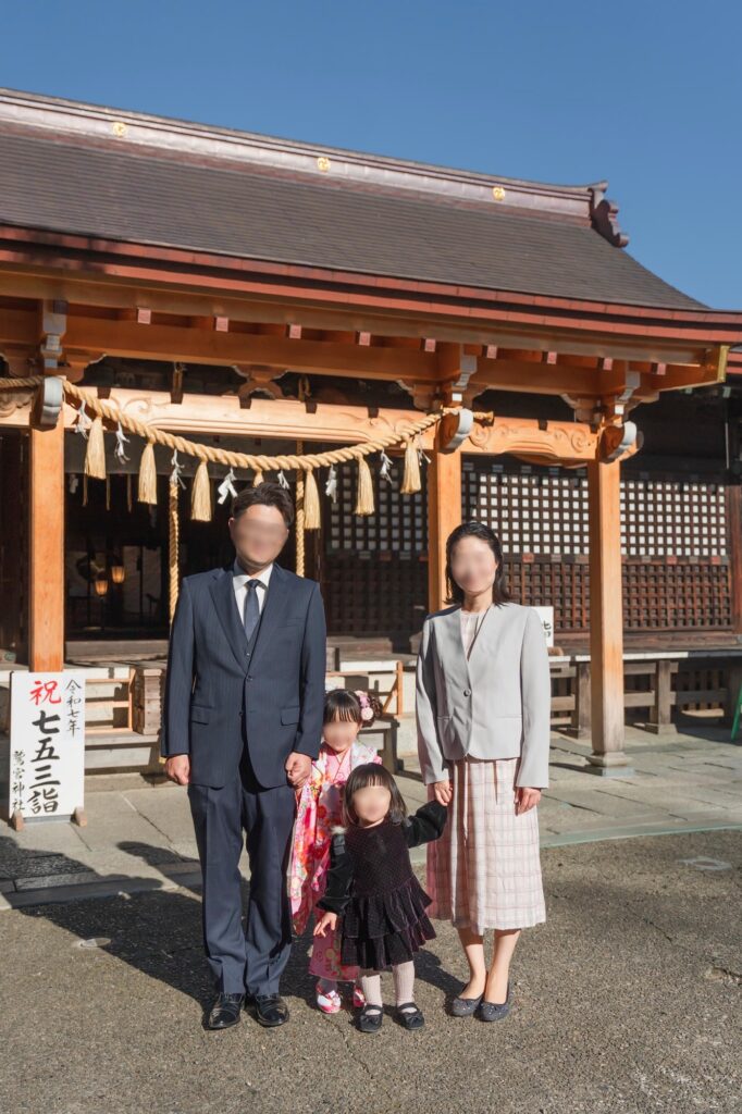 七五三で神社の本殿前に立つ家族写真（出張撮影の自然な雰囲気）